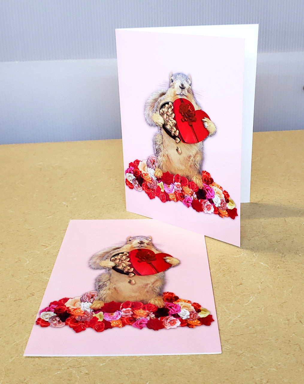 I'm Nuts About You | Funny Squirrel Valentine's Card. Image is a pink card with a fuzzy squirrel holding a red heart-shaped box of chocolates surrounded by white, pink, & redroses.