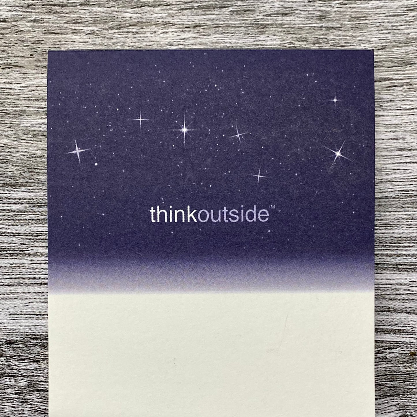 A notepad of 50 sheets of white paper featuring a drawing of a deep navy night sky with stars and the Big Dipper. The phrase Think Outside is printed beneath the image..