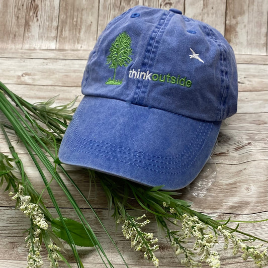 Periwinkle blue garment washed low profile baseball cap with the embroidered silhouette of a tree and bird and the words Think Outside.