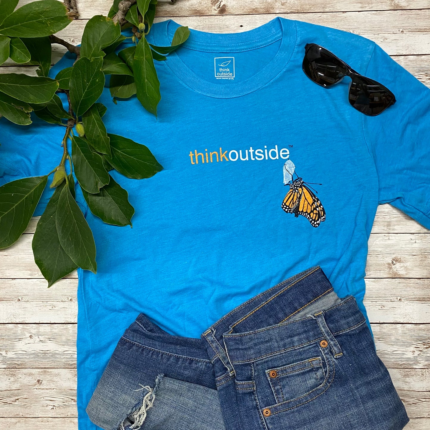 Hand drawn Monarch butterfly on a super soft heather aqua graphic tee for nature lovers. Features the phrase Think Outside.