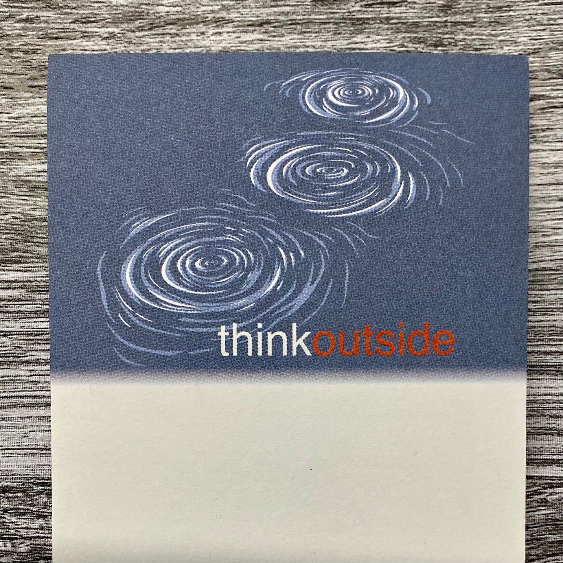 A notepad of 50 sheets of paper featuring a drawing of a rock skipping over water. It also includes the phrase Think Outside