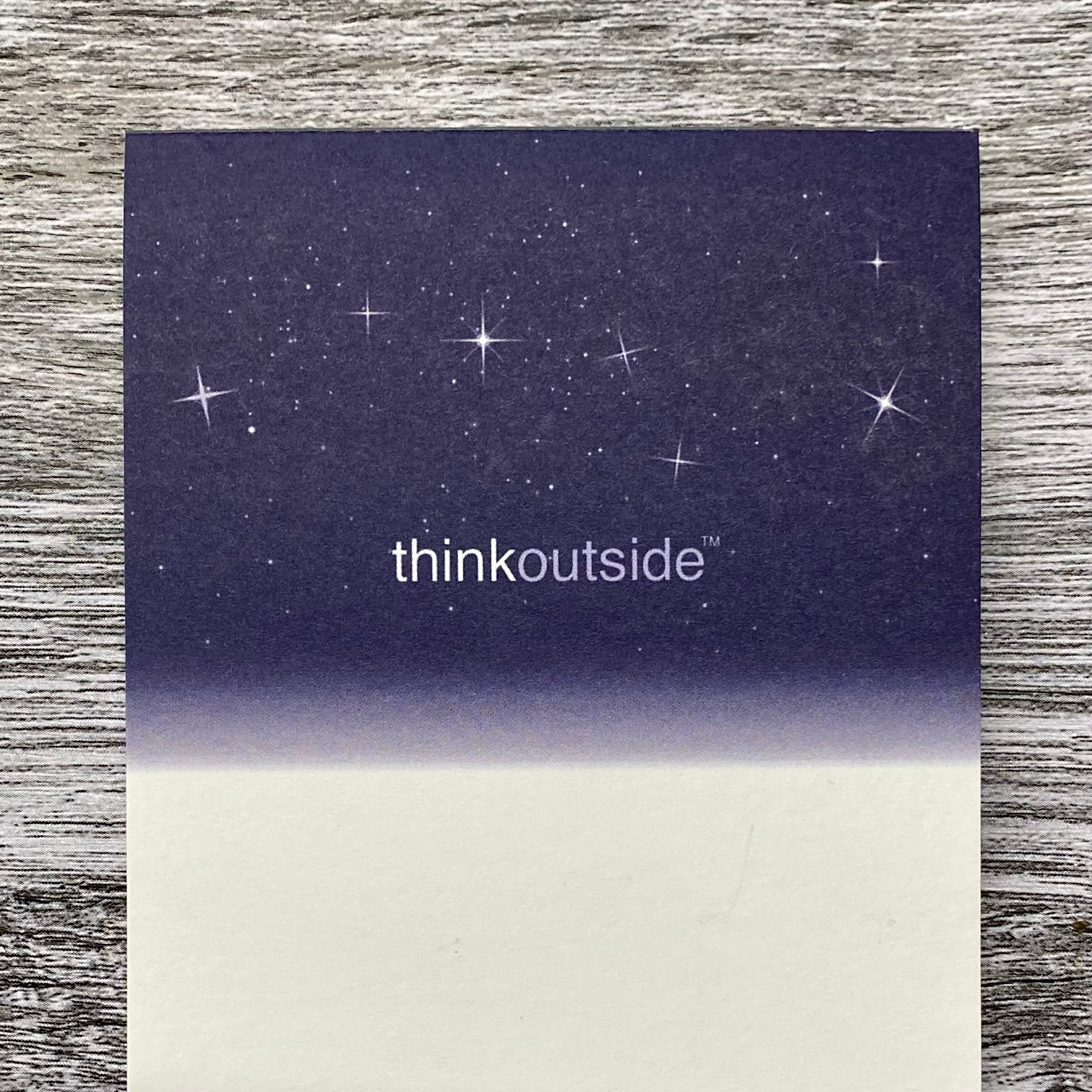 A notepad of 50 sheets of white paper featuring a drawing of a deep navy night sky with stars and the Big Dipper. The phrase Think Outside is printed beneath the image..