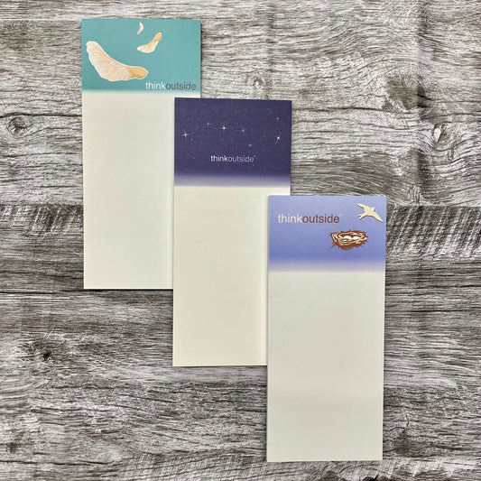 Three nature inspired notepads of 50  sheets each, one featuring maple seeds spinning in the air, one with the big dipper on a deep navy sky, and one with a bird's nest of eggs .  All include the phrase Think Outside.
