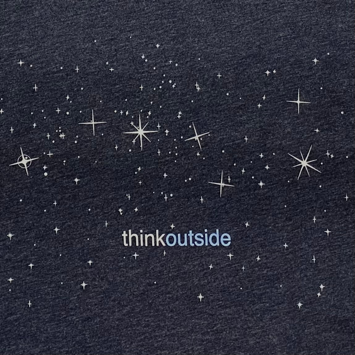 A night sky full of stars with the Big Dipper on a super soft heather midnight navy graphic tee for outdoor lovers.Features the phrase Think Outside.
