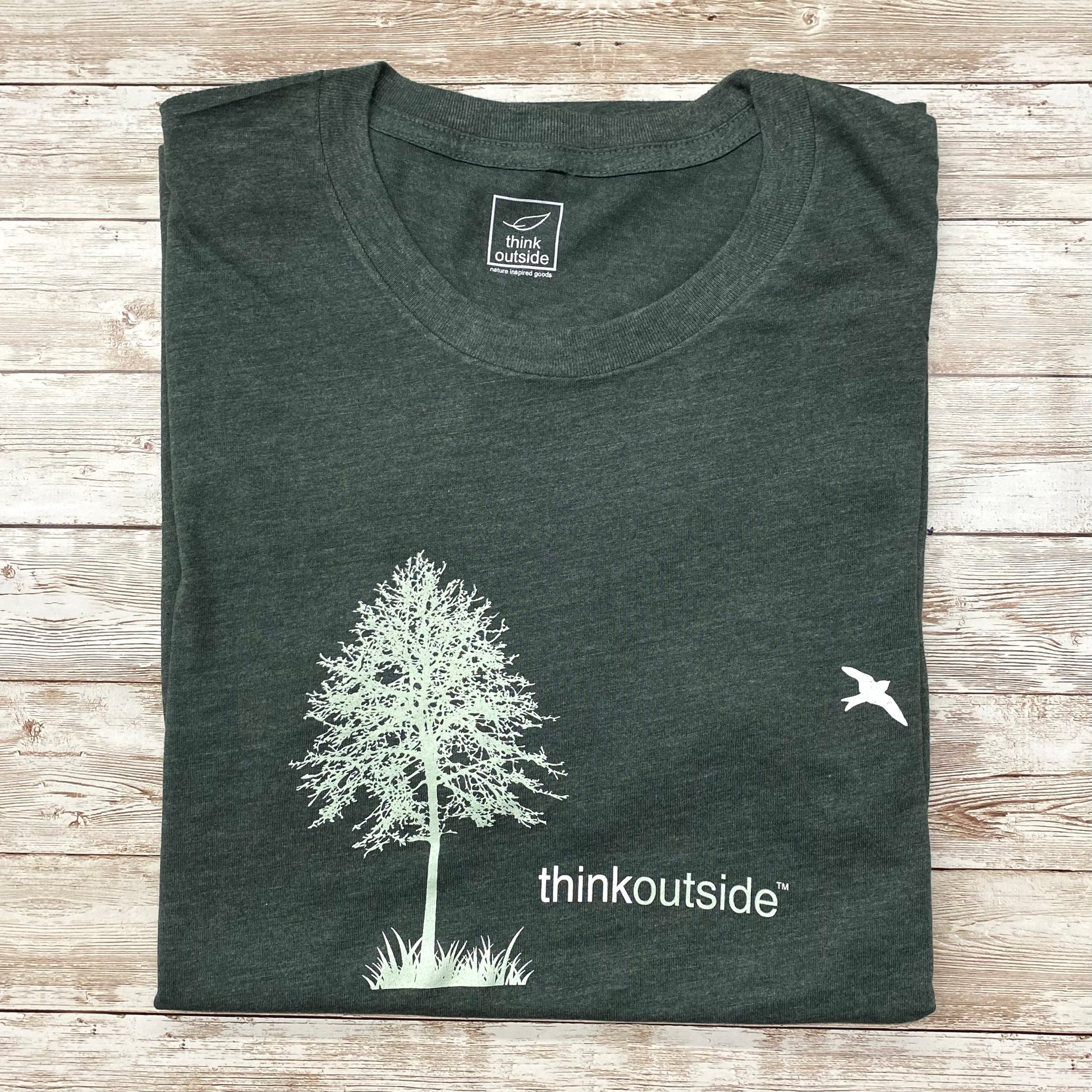 Super soft, heather green botanical, camping graphic unisex tee with tree and bird silhouette. Features the phrase Think Outside.